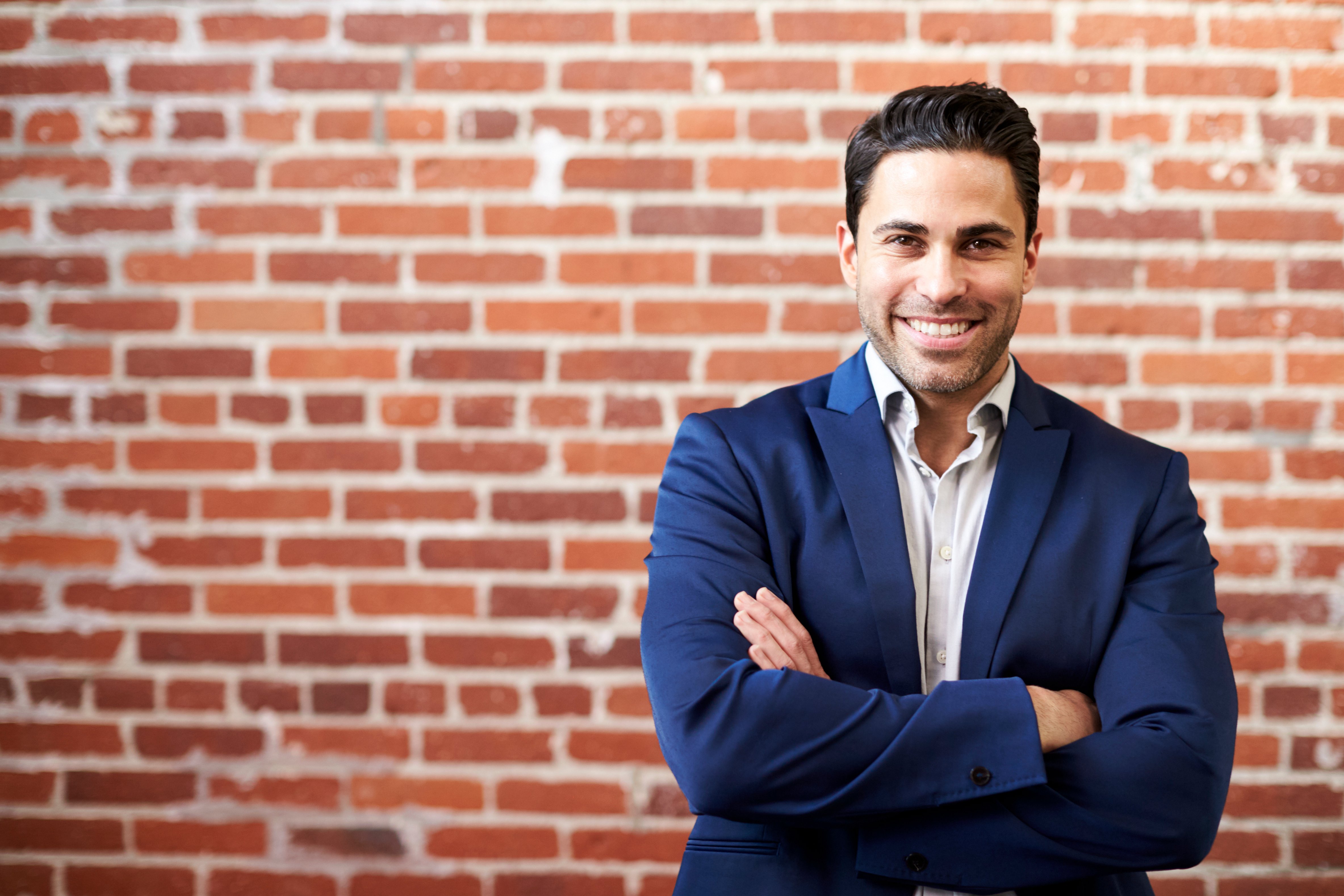 portrait-of-smiling-mature-businessman-standing-ag-2021-08-26-16-15-12-utc